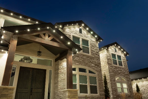 Warm white permanent accent lighting tracing the roofline of a two-story stucco home at dusk