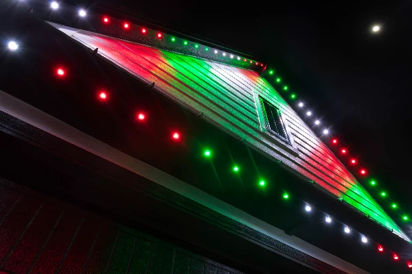 Pink and red Valentine's Day lighting along a front porch roofline