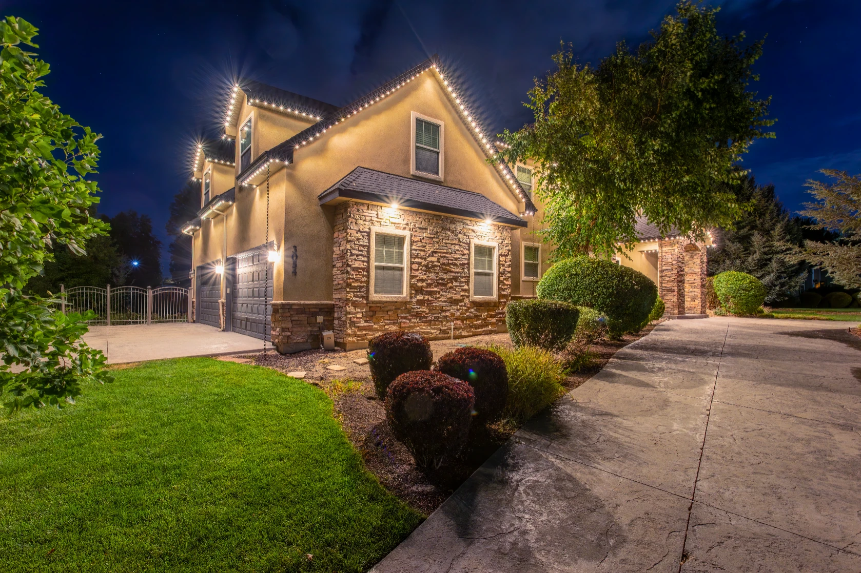Security-mode white lighting illuminating a driveway and front entry at night