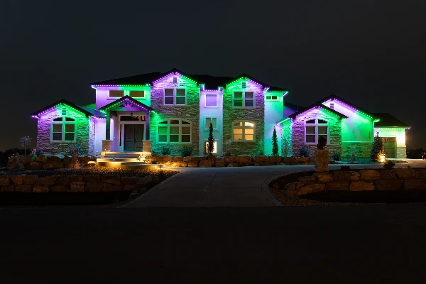 Teal and purple party lighting washing across a home's front facade