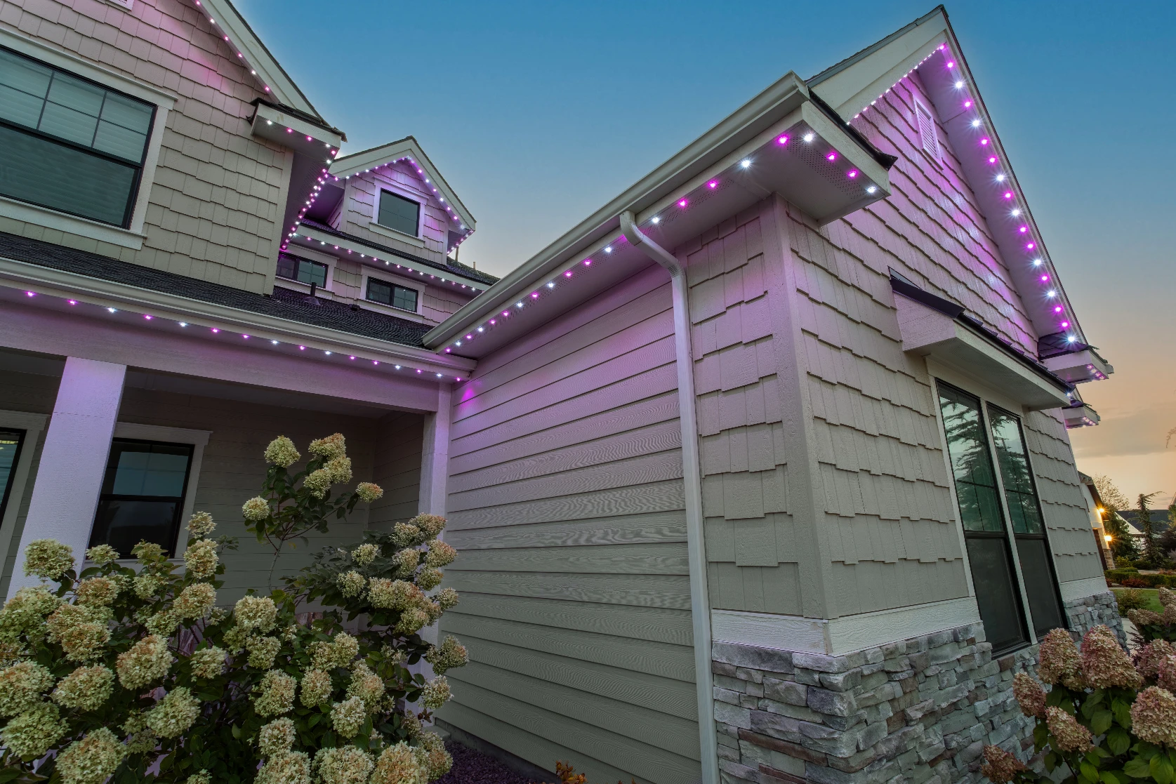 Permanent lighting outlining the full front elevation of a suburban two-story home
