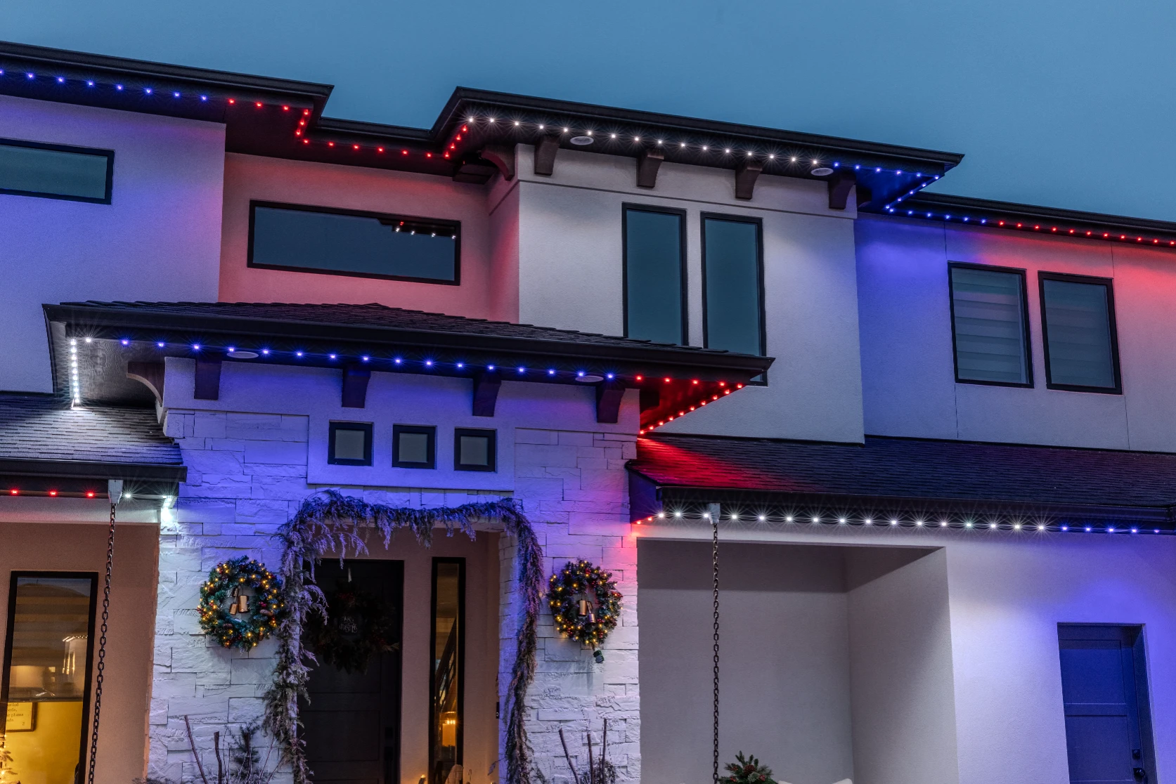 Deep blue Hanukkah lighting along the gables of a two-story home