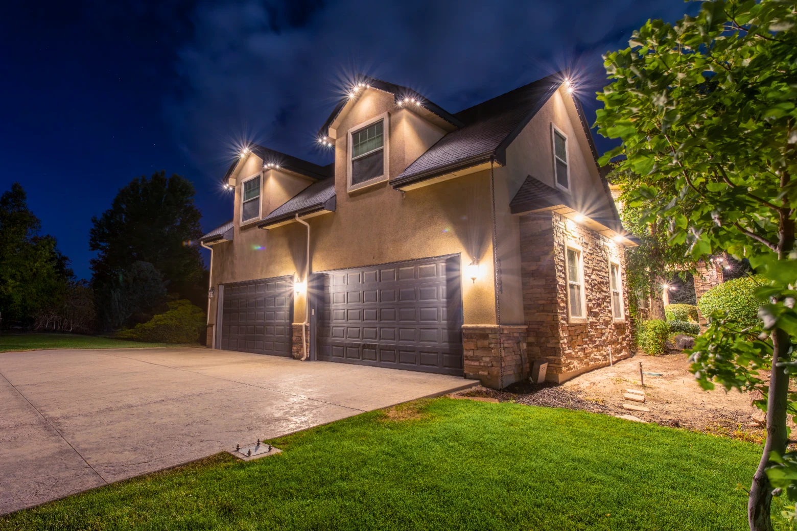 Warm accent lighting along a covered porch and columns of a ranch-style house