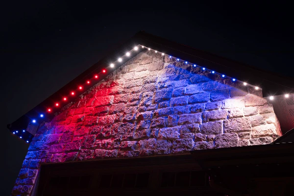 Green St. Patrick's Day lighting tracing the peaks of a brick home
