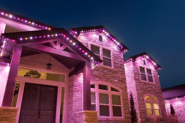 Orange and purple Halloween lighting glowing across a home's eaves and gables