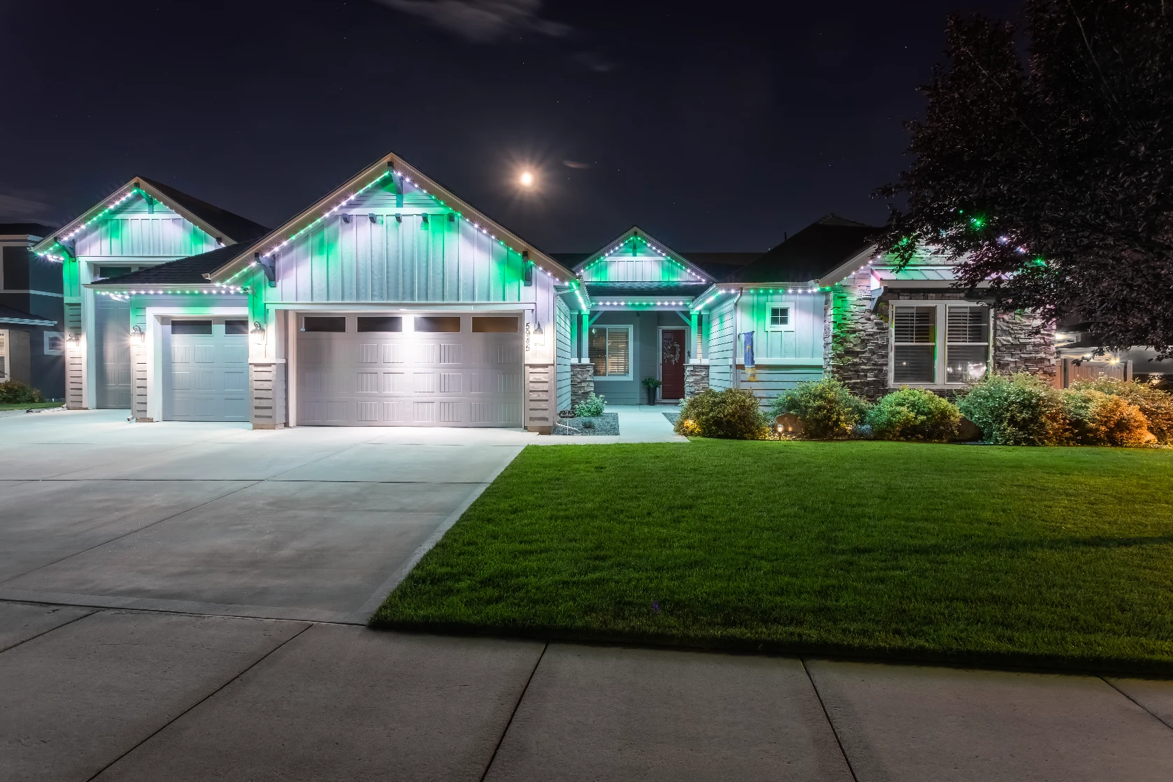 Crisp white roofline lighting on a dark-trim modern home against a twilight sky