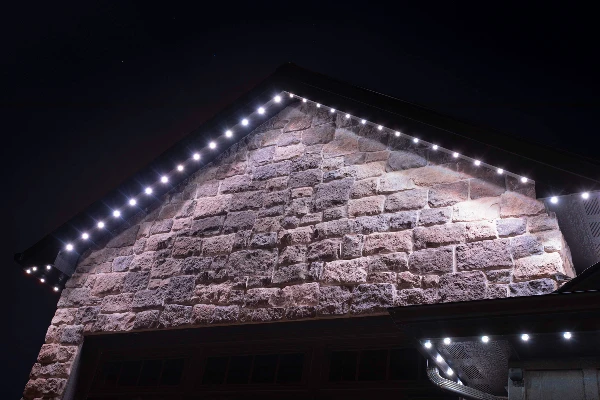 Permanent LED channel lighting highlighting the peaks of a brick two-story home