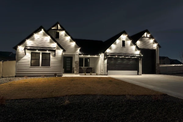Crisp white roofline lighting on a dark-trim modern home against a twilight sky